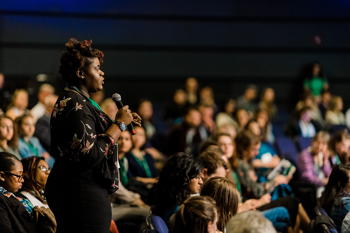 Iana	Davis, a student at Misericordia University, asks a question after NowThis gave their presentation.